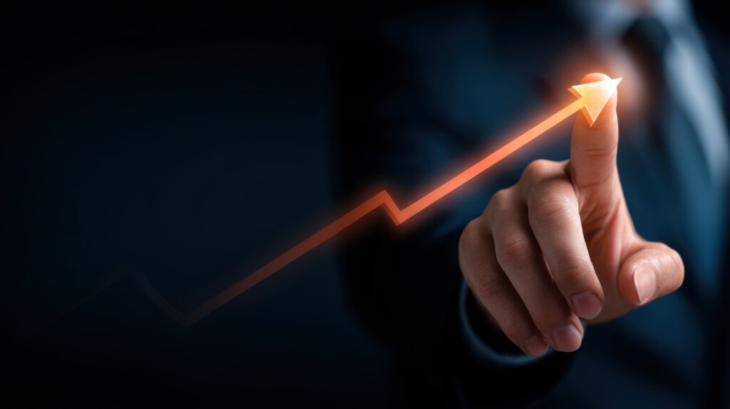 Businessman finger touching glowing upward arrow with growth chart representing financial growth, success and business performance